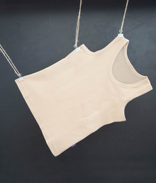  A beige unisex EMF protective vest with short sleeves, made of a silver fiber and beechwood soft material, hanging against a dark background