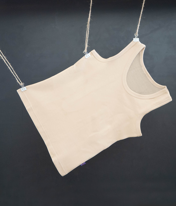 A beige unisex EMF protective vest with short sleeves, made of a silver fiber and beechwood soft material, hanging against a dark background