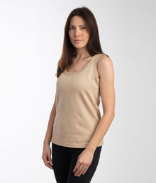  A woman wearing a beige sleeveless EMF protective vest Leblok paired with black jeans.