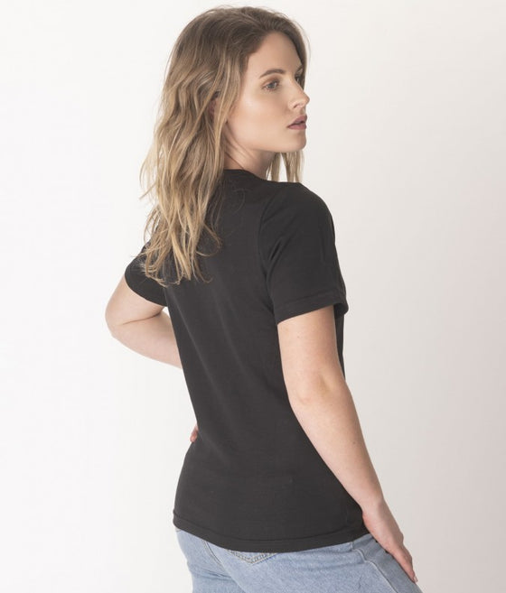 A woman wearing black EMF blocking T-shirt paired with blue jeans
