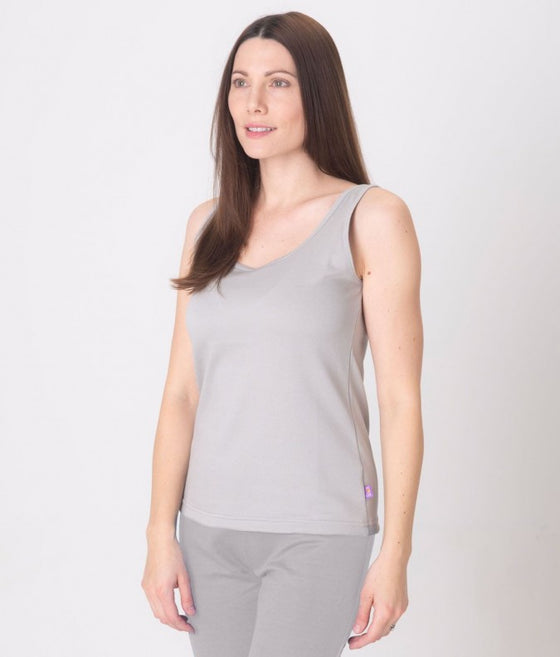 A woman wearing a gray EMF protective vest and matching EMF protective leggings Leblok